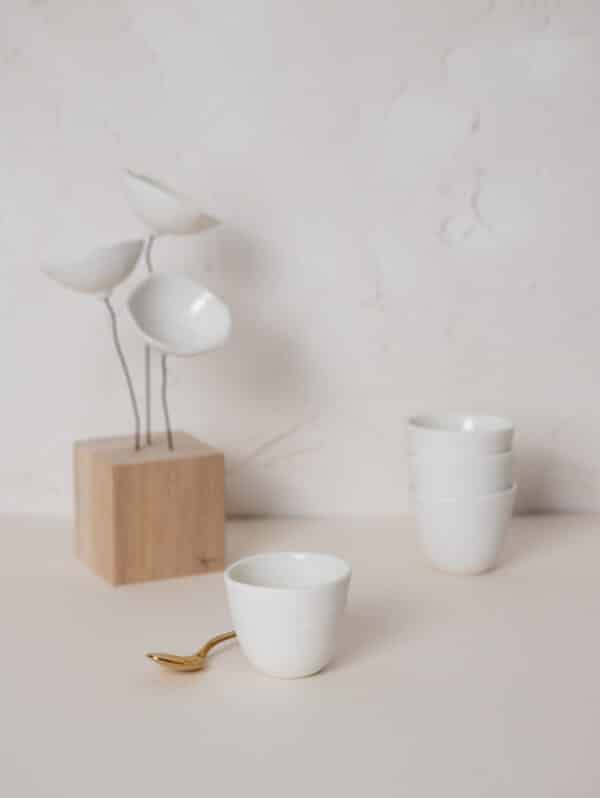Fleurs blanches en porcelaine sur élégant socle en chêne